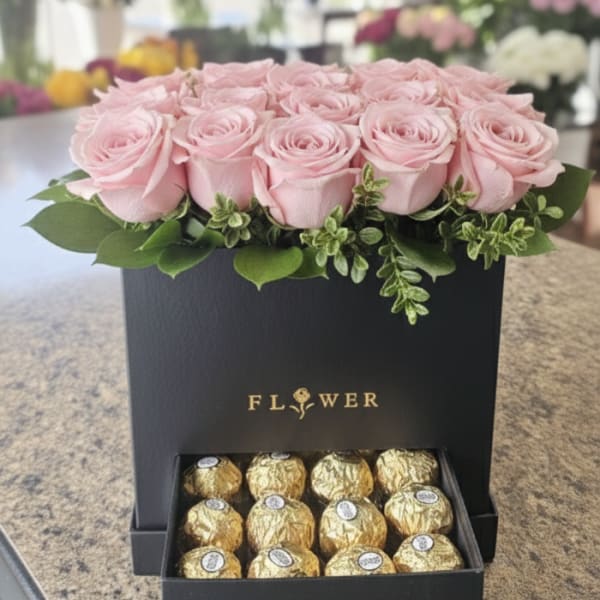 Pink roses in a black gift box with chocolates in a drawer below