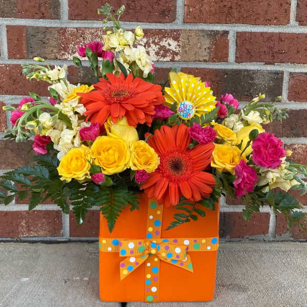 Bright mixed bouquet in an orange gift box with a polka-dot ribbon