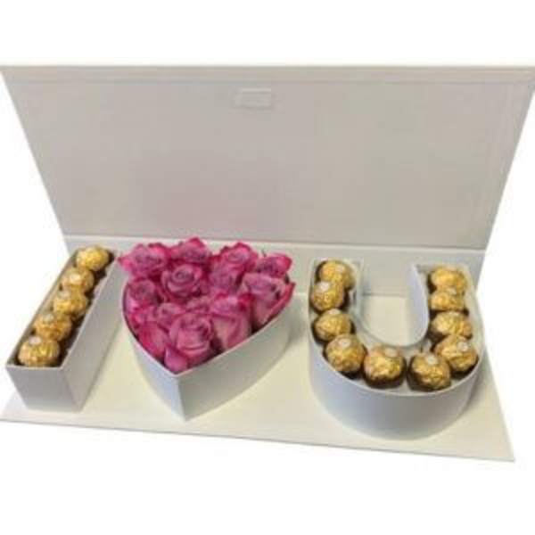 Gift box with pink roses and Ferrero Rocher chocolates arranged as letters.
