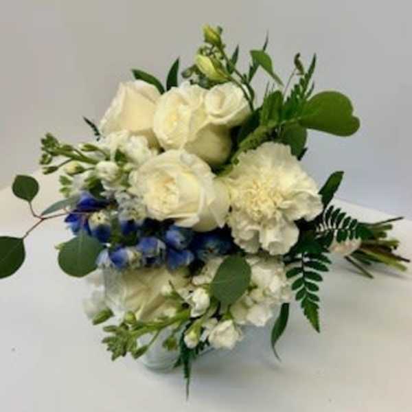 White roses and carnations with blue flowers in a vase