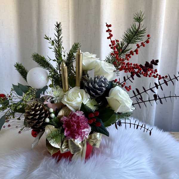 Holiday arrangement with white roses, pinecones, and red berries