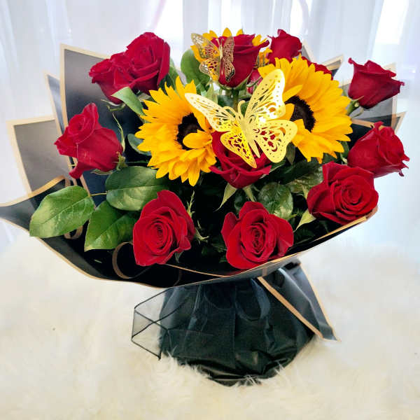 Bouquet of red roses and yellow sunflowers with butterfly picks