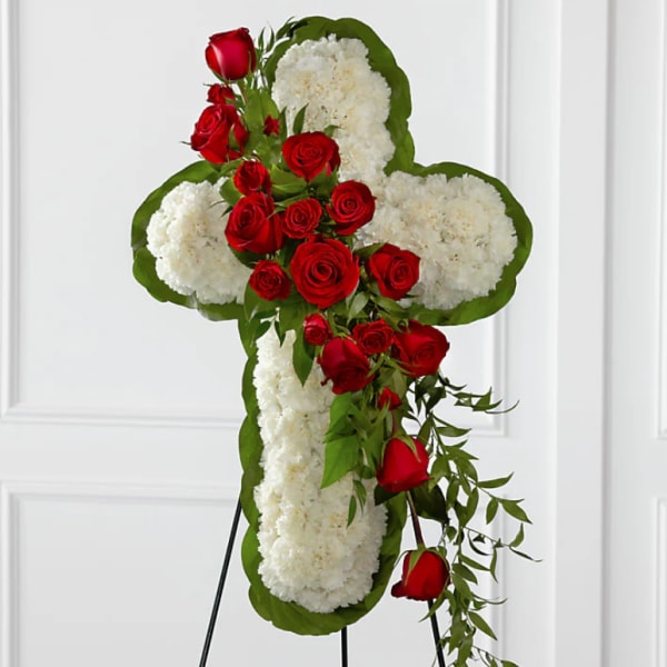 Cross-shaped floral tribute with white flowers and red roses