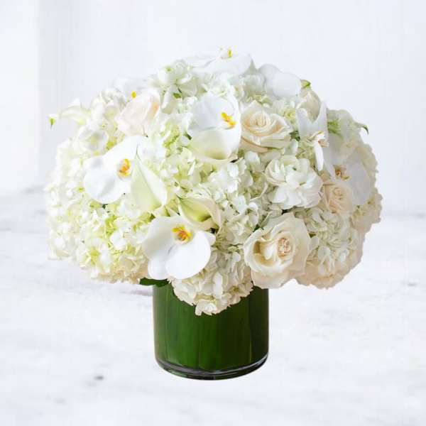White floral arrangement in a green glass vase