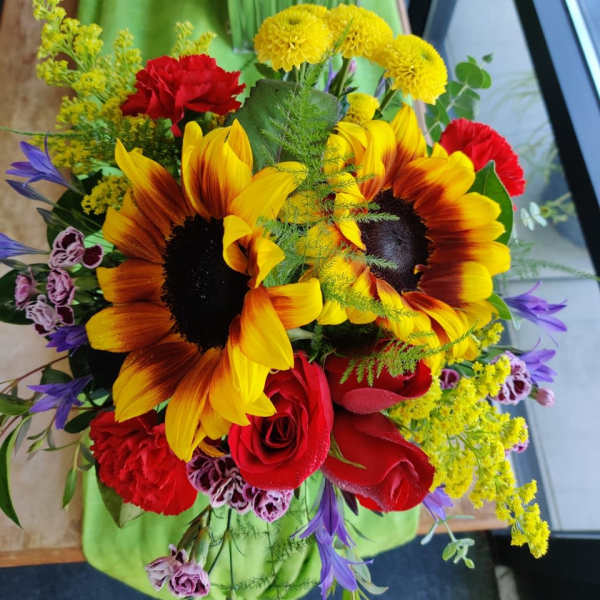 Bouquet of sunflowers, red roses, and mixed accent flowers