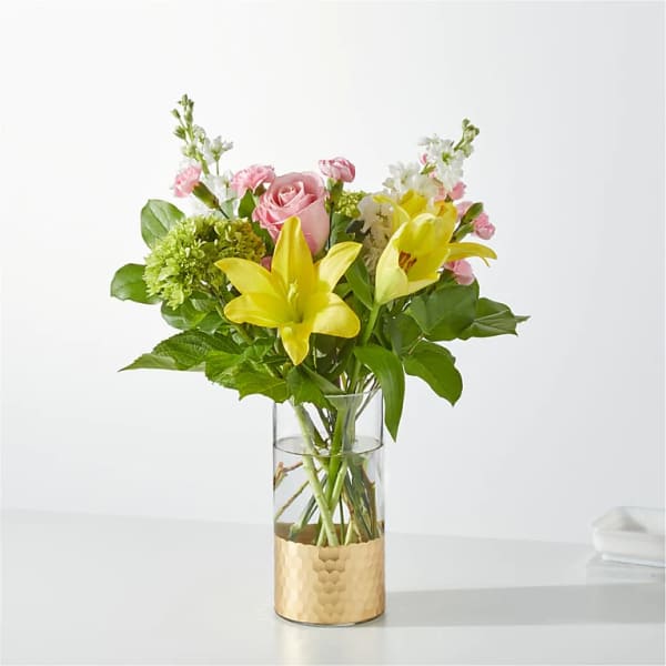 Pink roses and yellow lilies in a clear glass vase