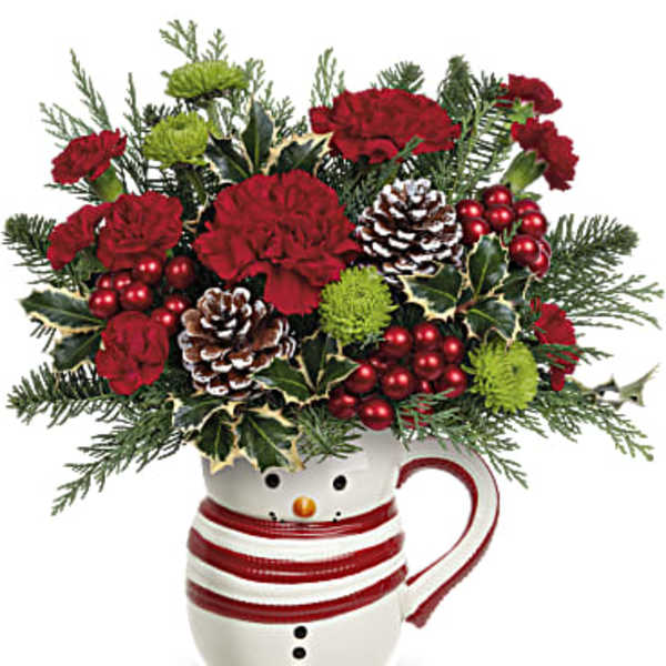Christmas bouquet in a snowman mug with red carnations and pinecones