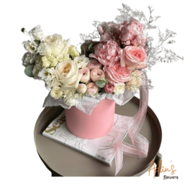 Pink and white rose bouquet in a pink hatbox with a ribbon