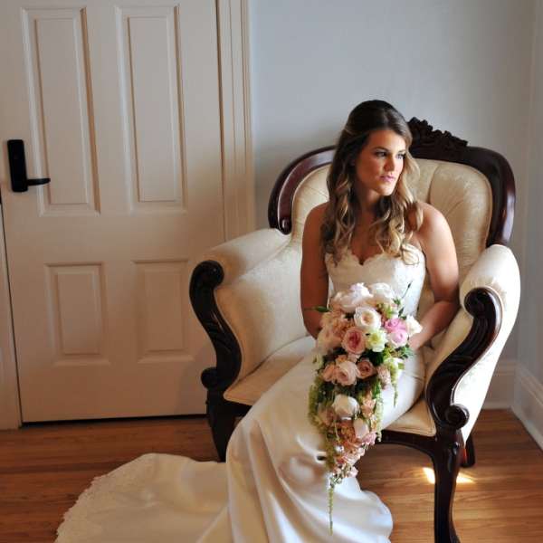Bride in a white gown holding a cascading bouquet of pink and white flowers