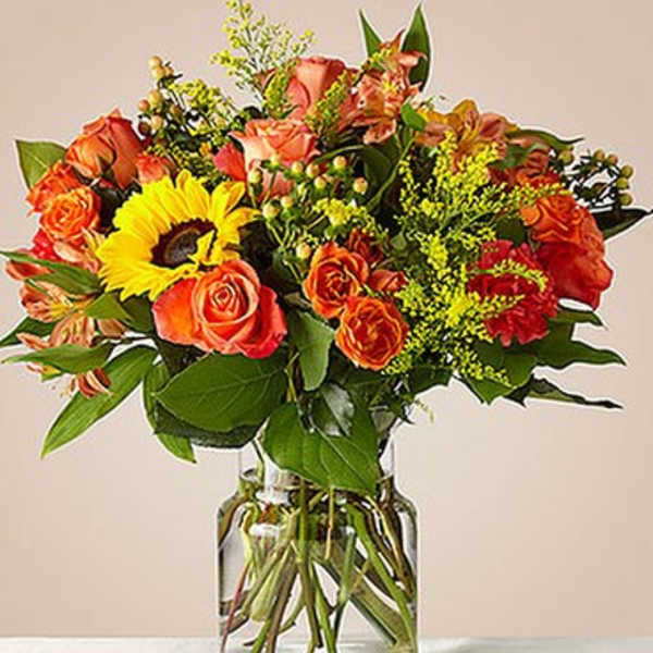 Orange and yellow mixed bouquet in a clear glass vase