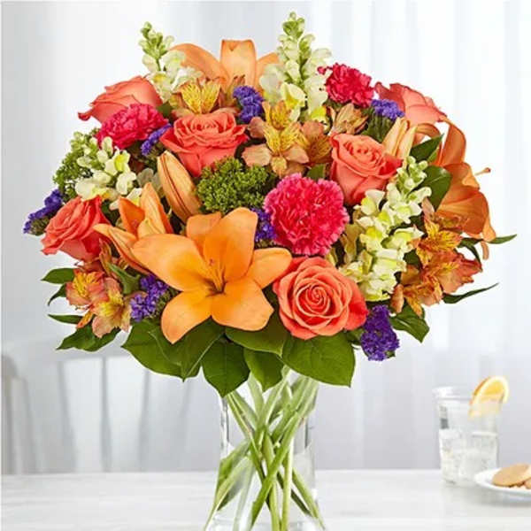 Orange and coral bouquet in a clear glass vase