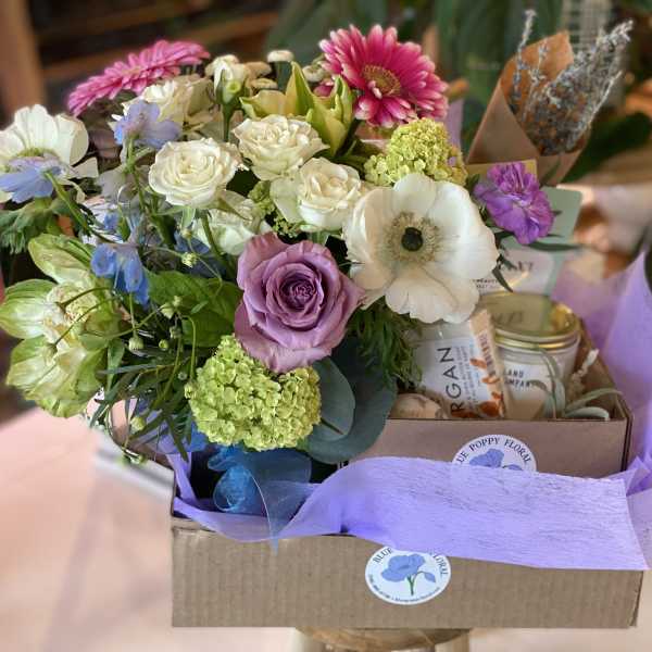 Mixed bouquet with roses, anemones, and daisies in a gift box