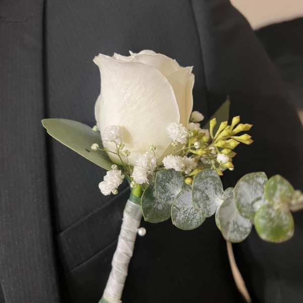 White rose boutonniere with small white filler flowers and eucalyptus