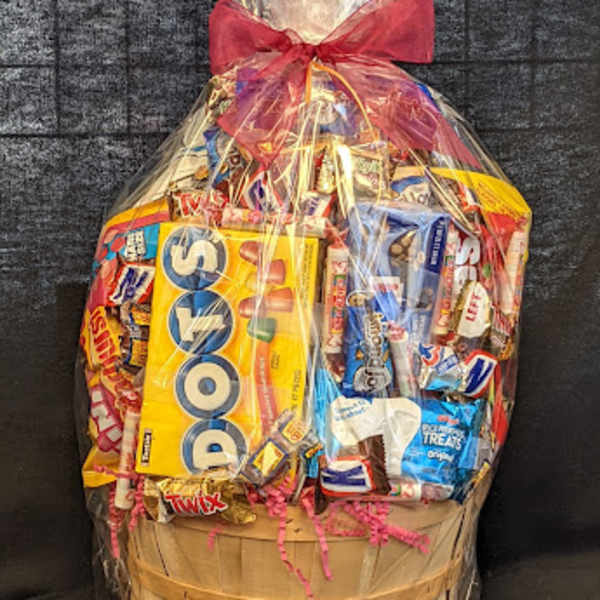 Basket of assorted candy wrapped in clear cellophane with a red bow