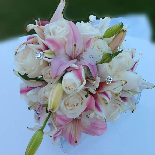 Pink and white bouquet of roses and lilies with jeweled accents