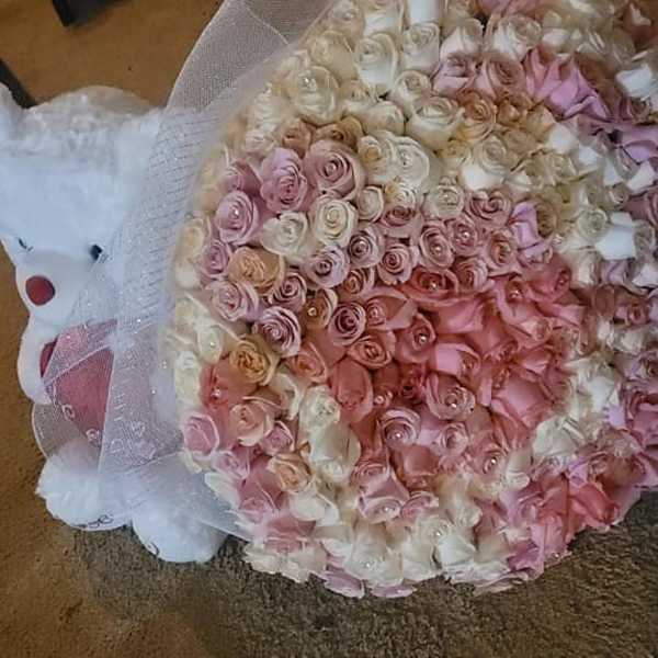 Large bouquet of pink and white roses with a white teddy bear