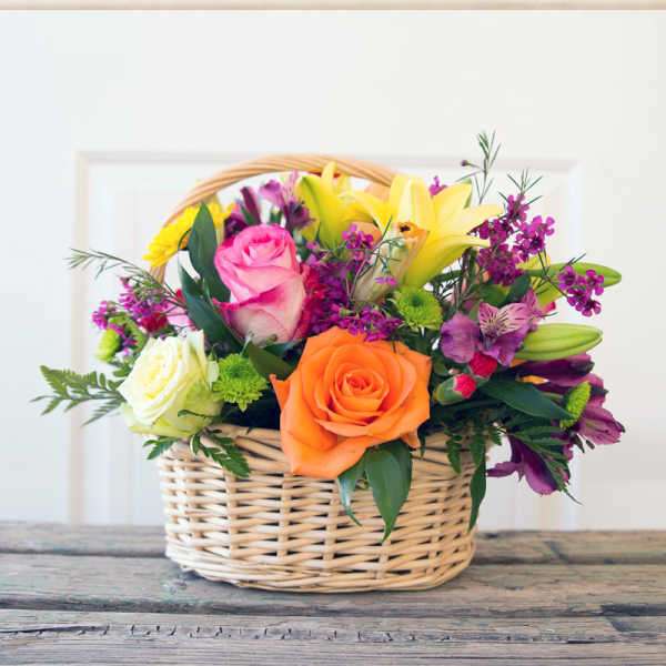 Mixed flower basket with roses, lilies, and purple blooms