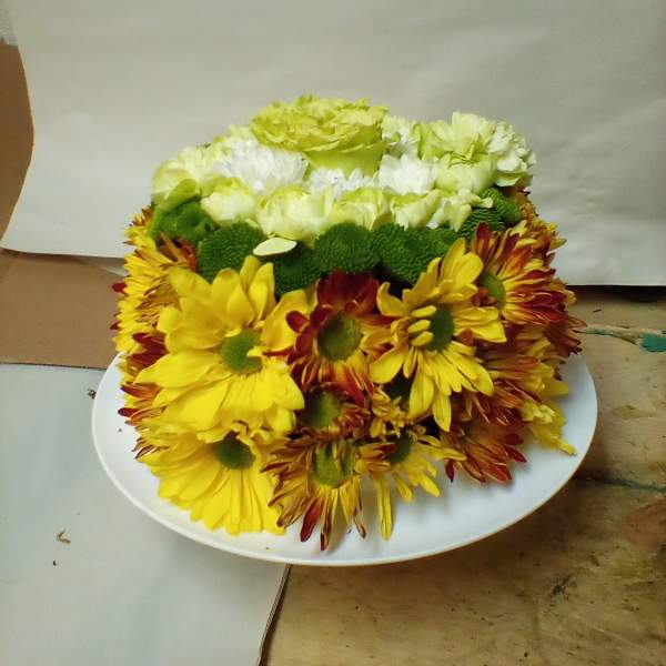 Yellow and white chrysanthemum arrangement on a white plate