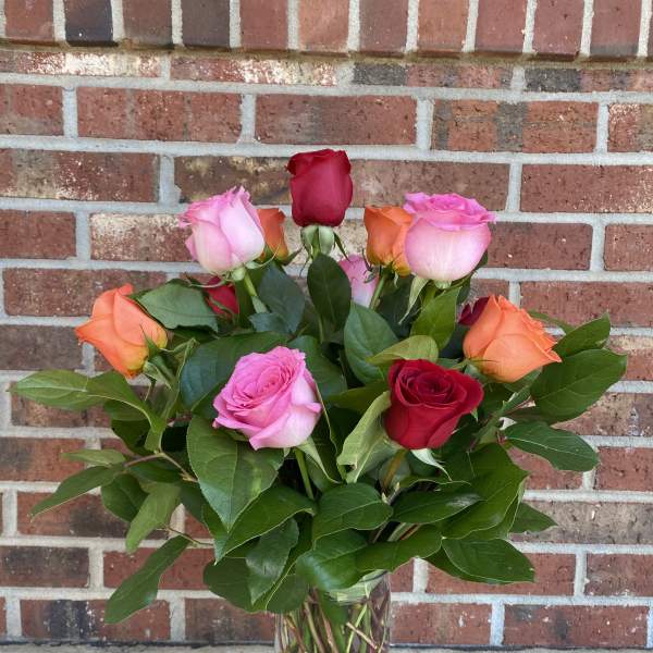 Bouquet of multicolored roses in a clear glass vase