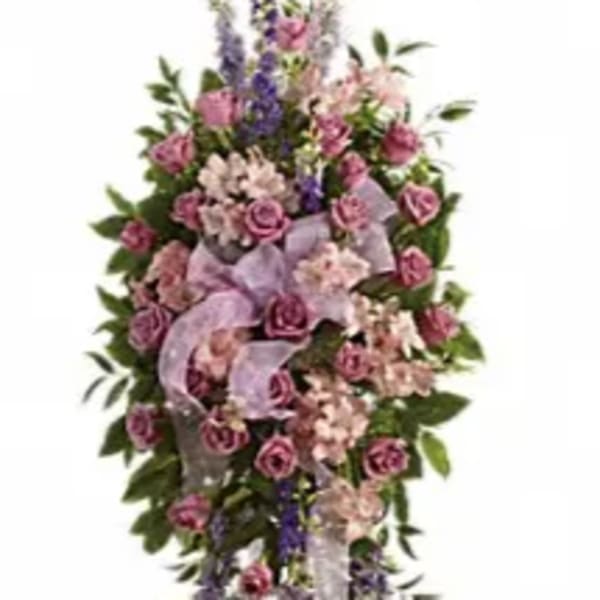 Tall standing floral spray with pink roses and purple flowers on a white ribbon stand