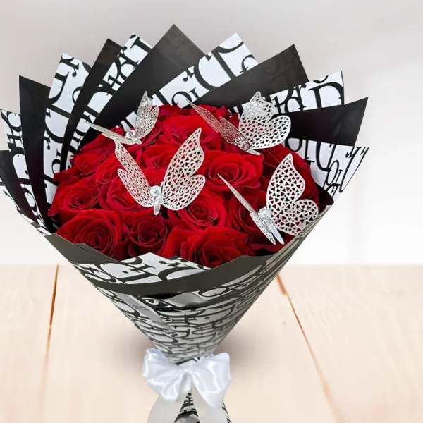 Bouquet of red roses wrapped in black-and-white paper with butterfly accents