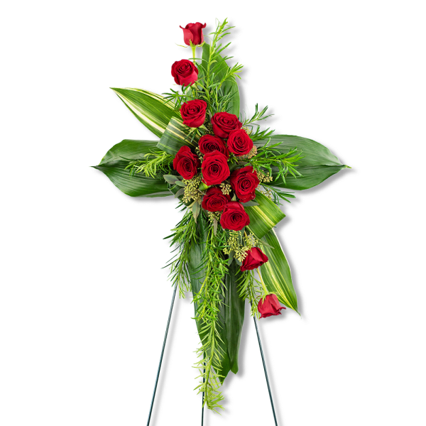 Standing floral spray of red roses and tropical leaves on an easel