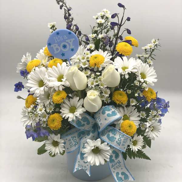 White daisies and yellow pompons in a blue vase with a baby boy balloon