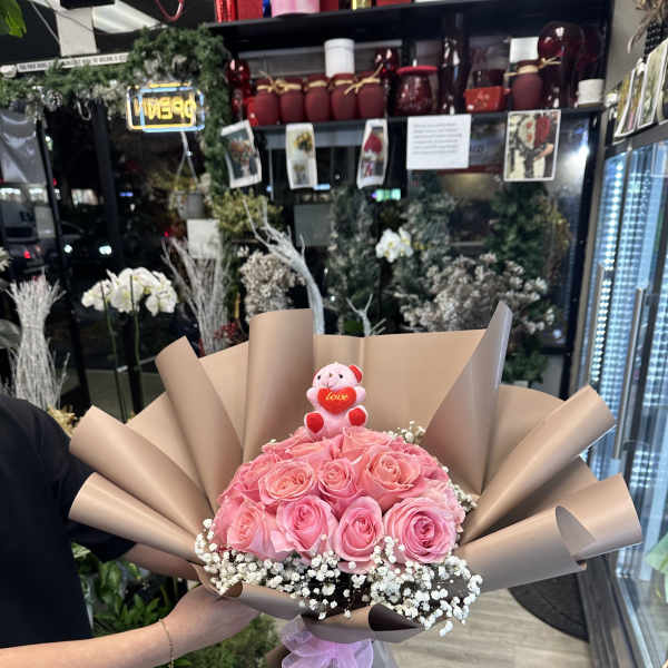 Pink rose bouquet with a small teddy bear and baby’s breath