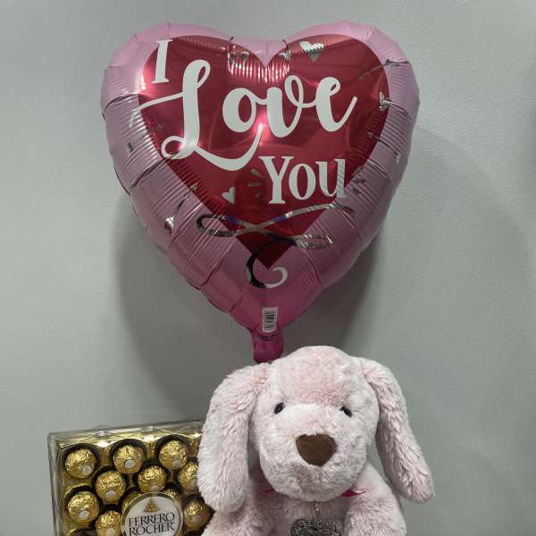Heart-shaped "I Love You" balloon with a pink plush dog and chocolates