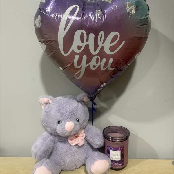 Heart-shaped "love you" balloon with a plush teddy bear and candle