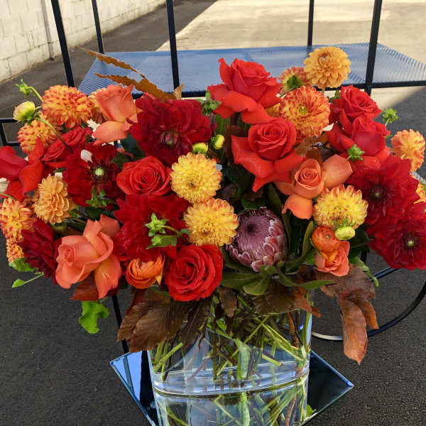 Bright red and orange mixed bouquet in a clear glass vase