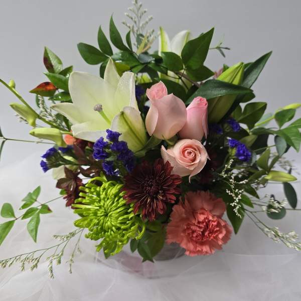Mixed bouquet with pink roses, white lilies, and colorful blooms
