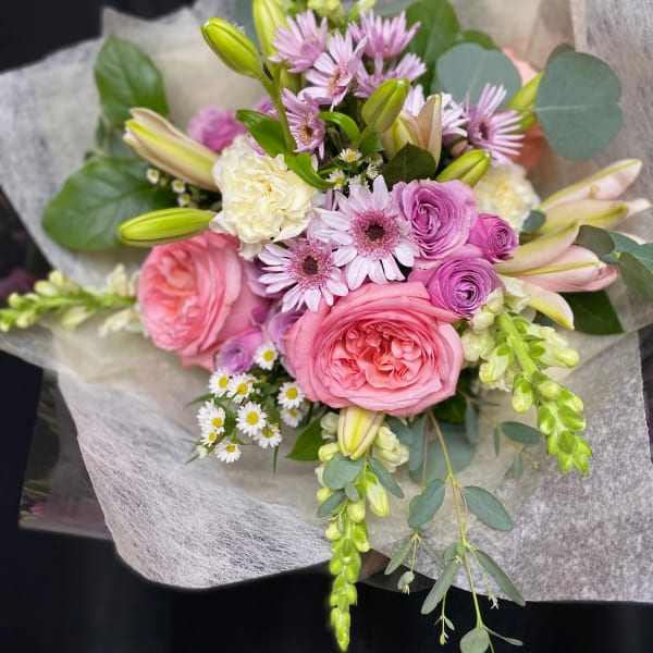 Pink and lavender bouquet with lilies and roses wrapped in paper