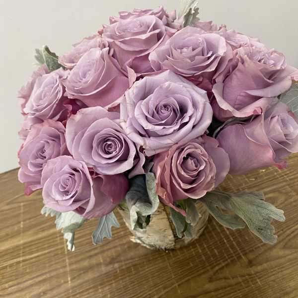Bouquet of lavender roses in a small wrapped container