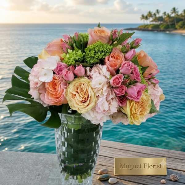 Pastel rose bouquet in a clear glass vase by the water