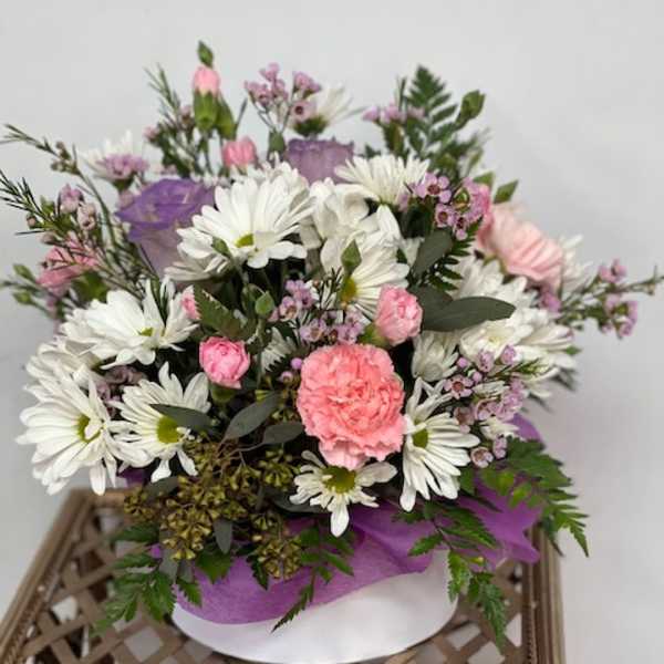 Pink and white mixed bouquet with daisies and carnations in a round box