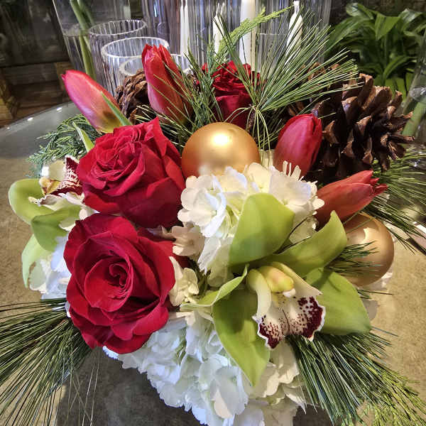 Red roses and green orchids with pinecones and gold ornaments