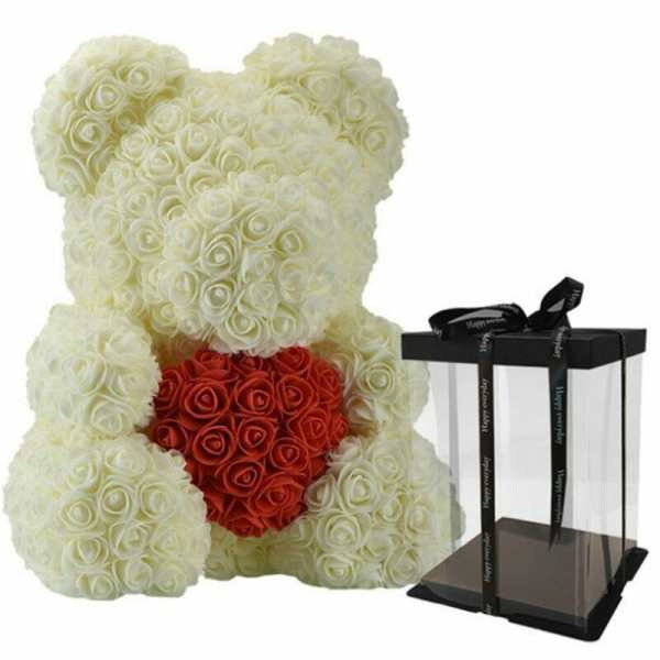 White rose teddy bear holding a red rose heart beside a clear gift box