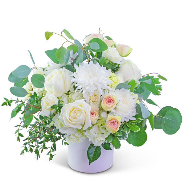 White roses and chrysanthemums in a white vase with green foliage