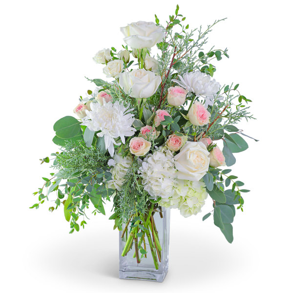 White roses and pink spray roses in a clear glass vase