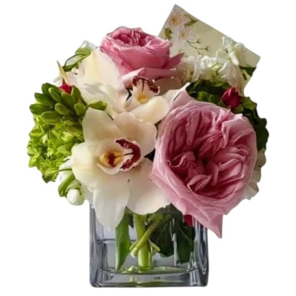 Pink roses and white orchids arranged in a clear glass vase