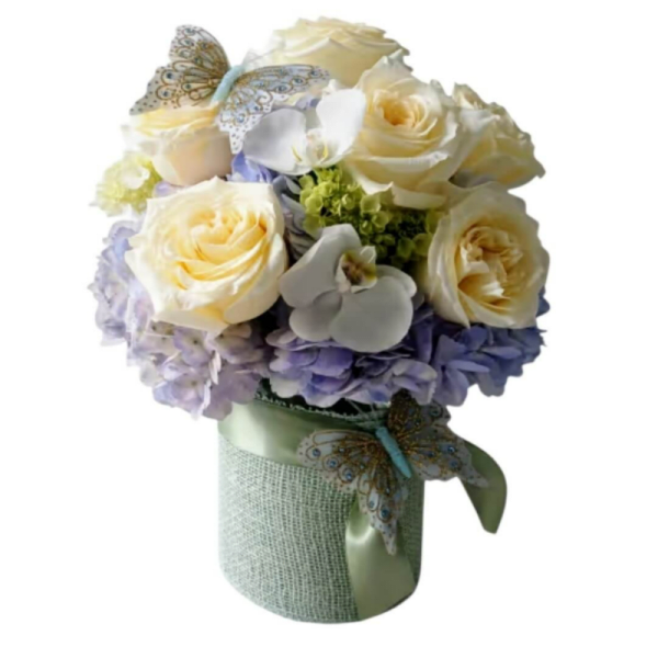 Cream roses and lavender hydrangeas in a wrapped bouquet with butterfly accents