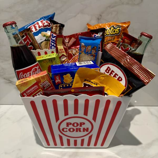 Popcorn bucket filled with soda bottles and assorted snack packs