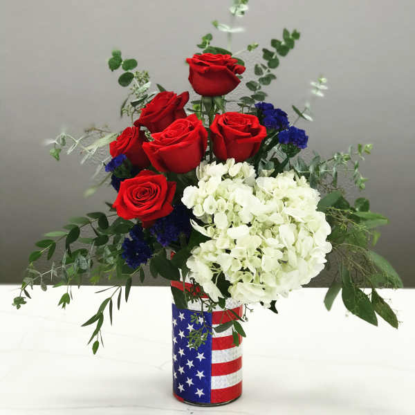 Red roses and white hydrangeas in a patriotic flag-wrapped vase