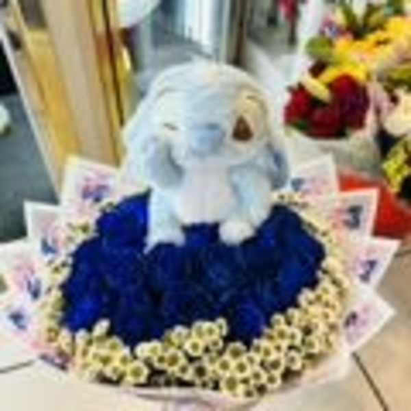 Stuffed bunny sitting in a ring of blue and white flowers