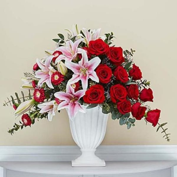 Red roses and pink lilies arranged in a white vase