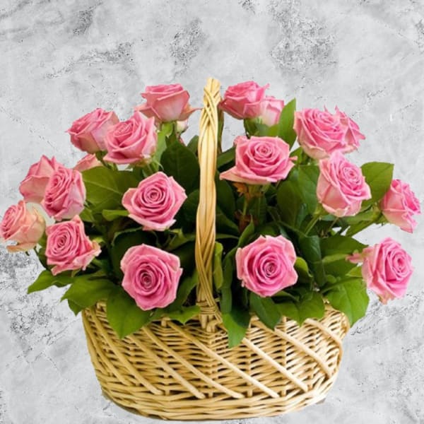 Basket of pink roses with green leaves