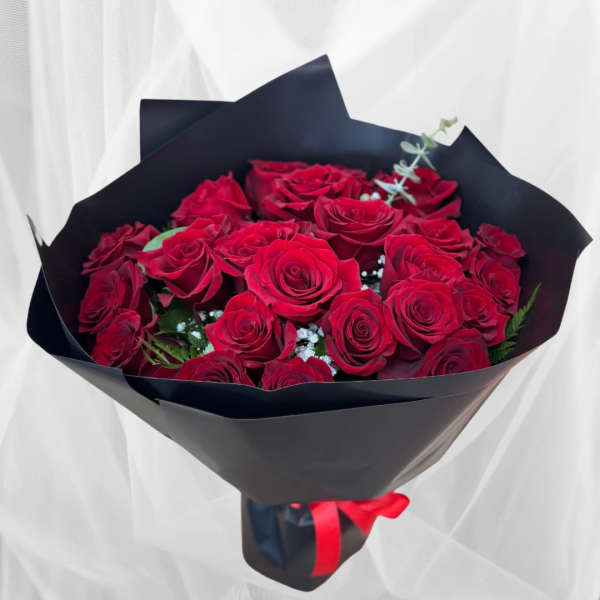 Bouquet of red roses wrapped in black paper with a red ribbon