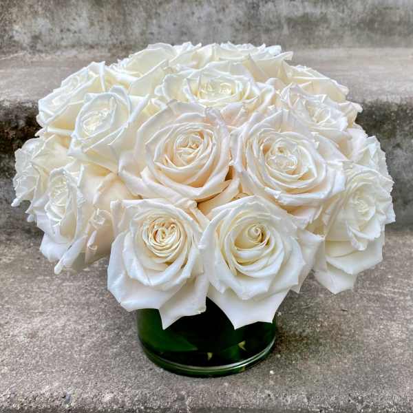 Round bouquet of white roses in a green glass vase