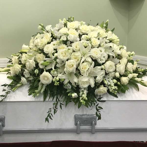 White floral casket spray with roses and lilies
